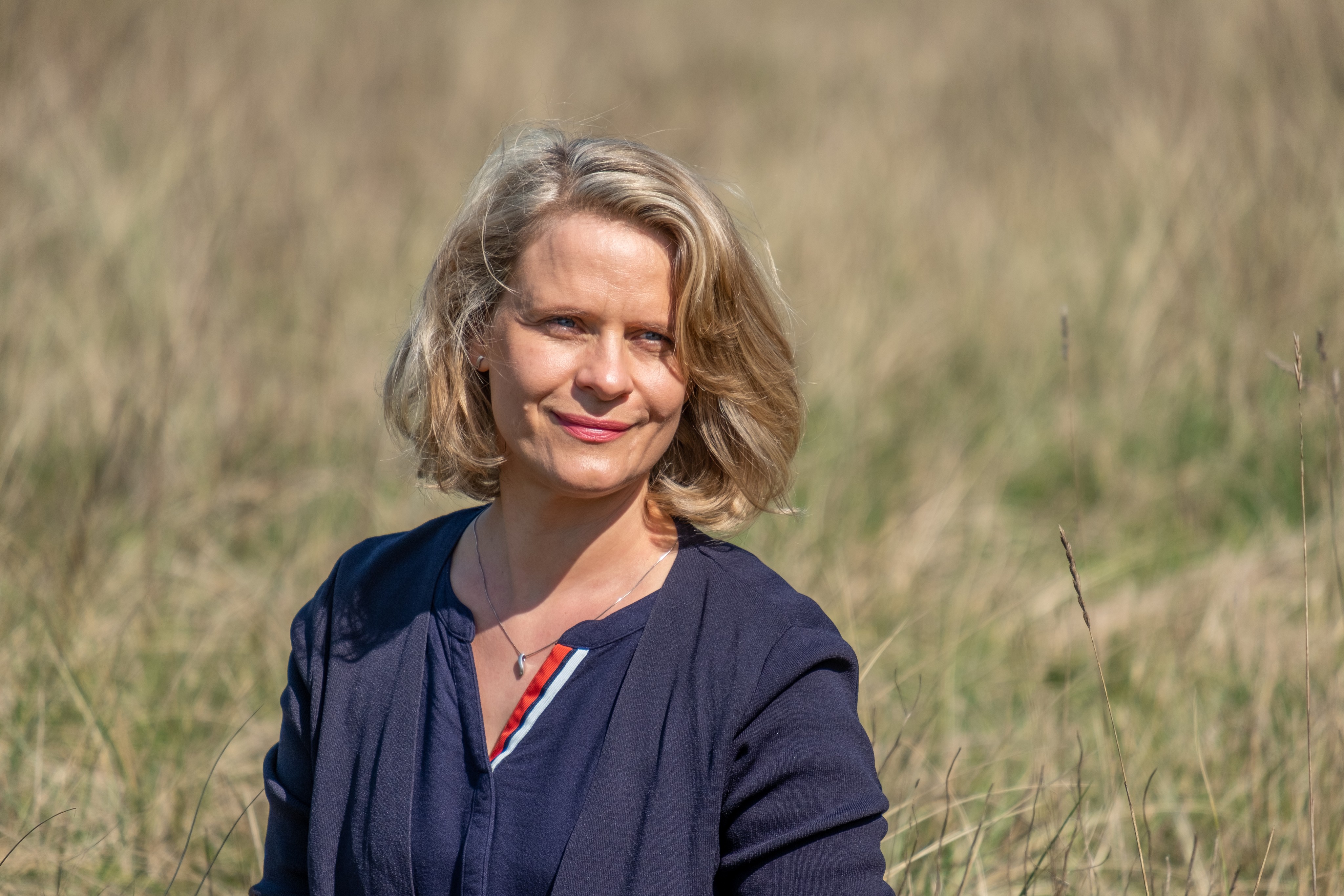 Eine Frau in blauem Oberteil in der Natur.